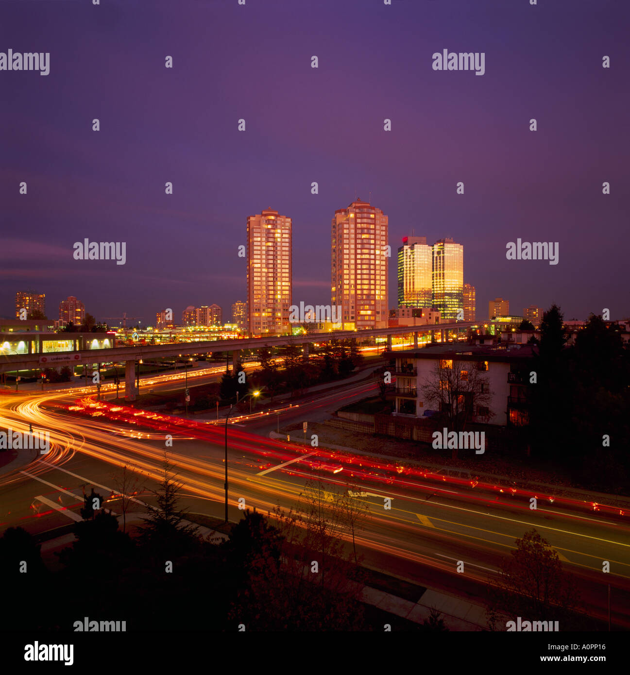 Burnaby, BC, Britisch-Kolumbien, Kanada - hohe Aufstieg Gebäude am Metrotown, Straße Ampel Streifen in der Nacht Stockfoto