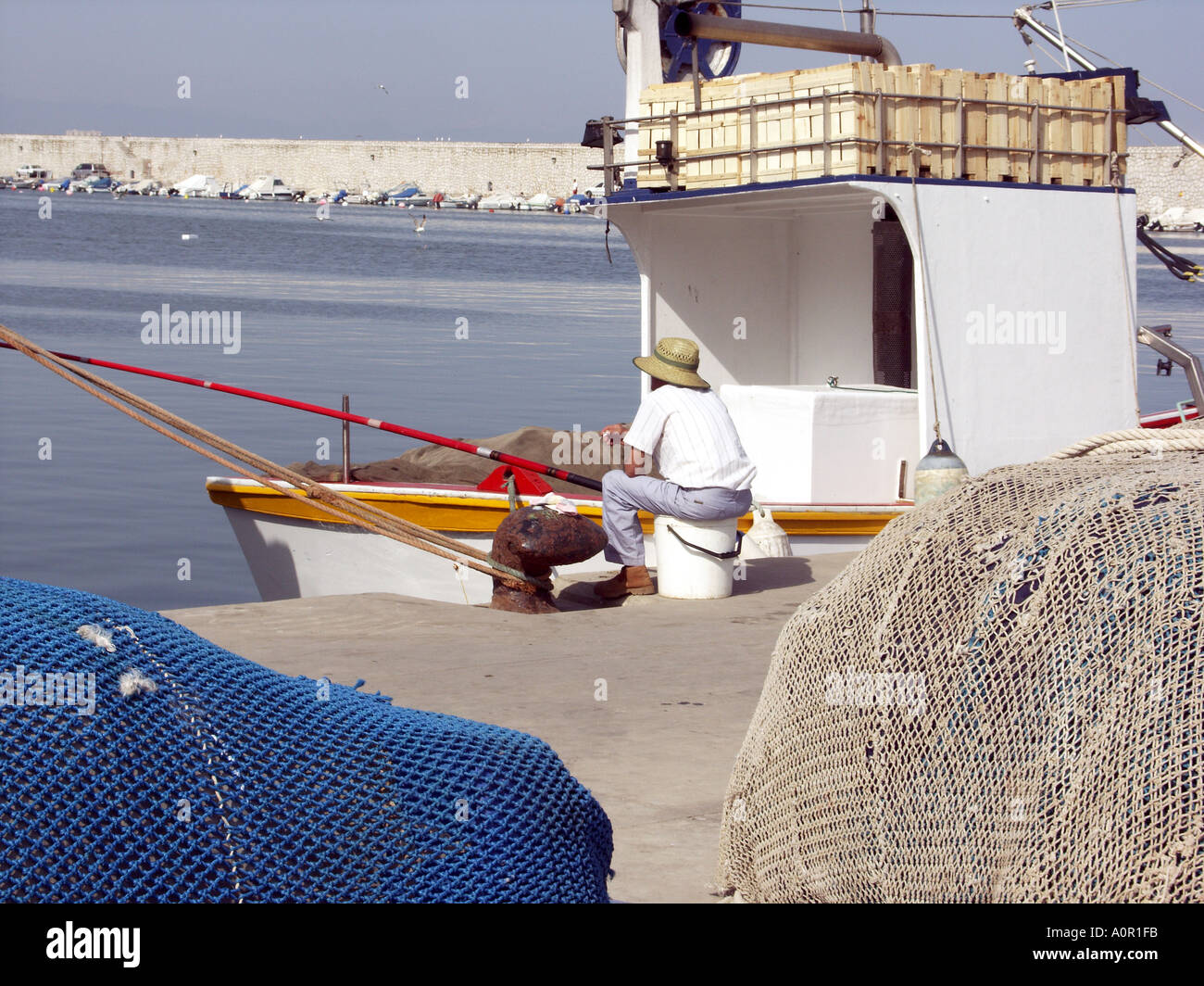 Angler Angeln mit Rute und Schnur neben einer kommerziellen Fischerboot, Puerto Deportivo de Fuengirola, Hafen von Fuengirola, Spanien Stockfoto