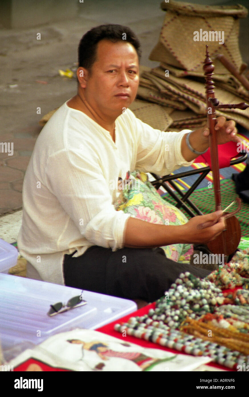 Einheimischen Handwerk Straße Verkäufer Mann spielt alte Musical instrument im freien Phitsanulok Thailand Südostasien Stockfoto