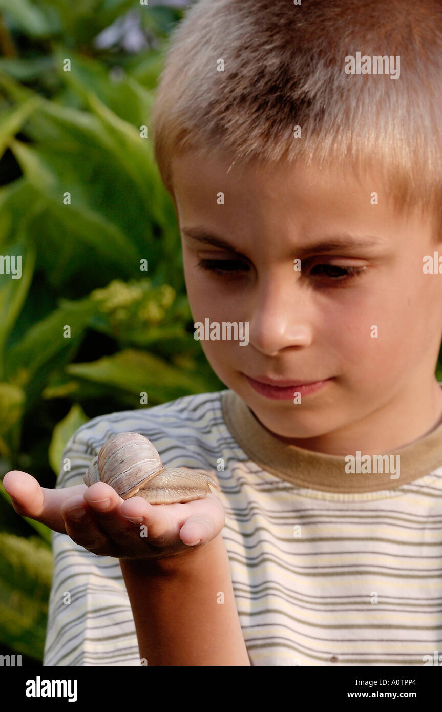Junge mit essbaren Schnecke Stockfoto