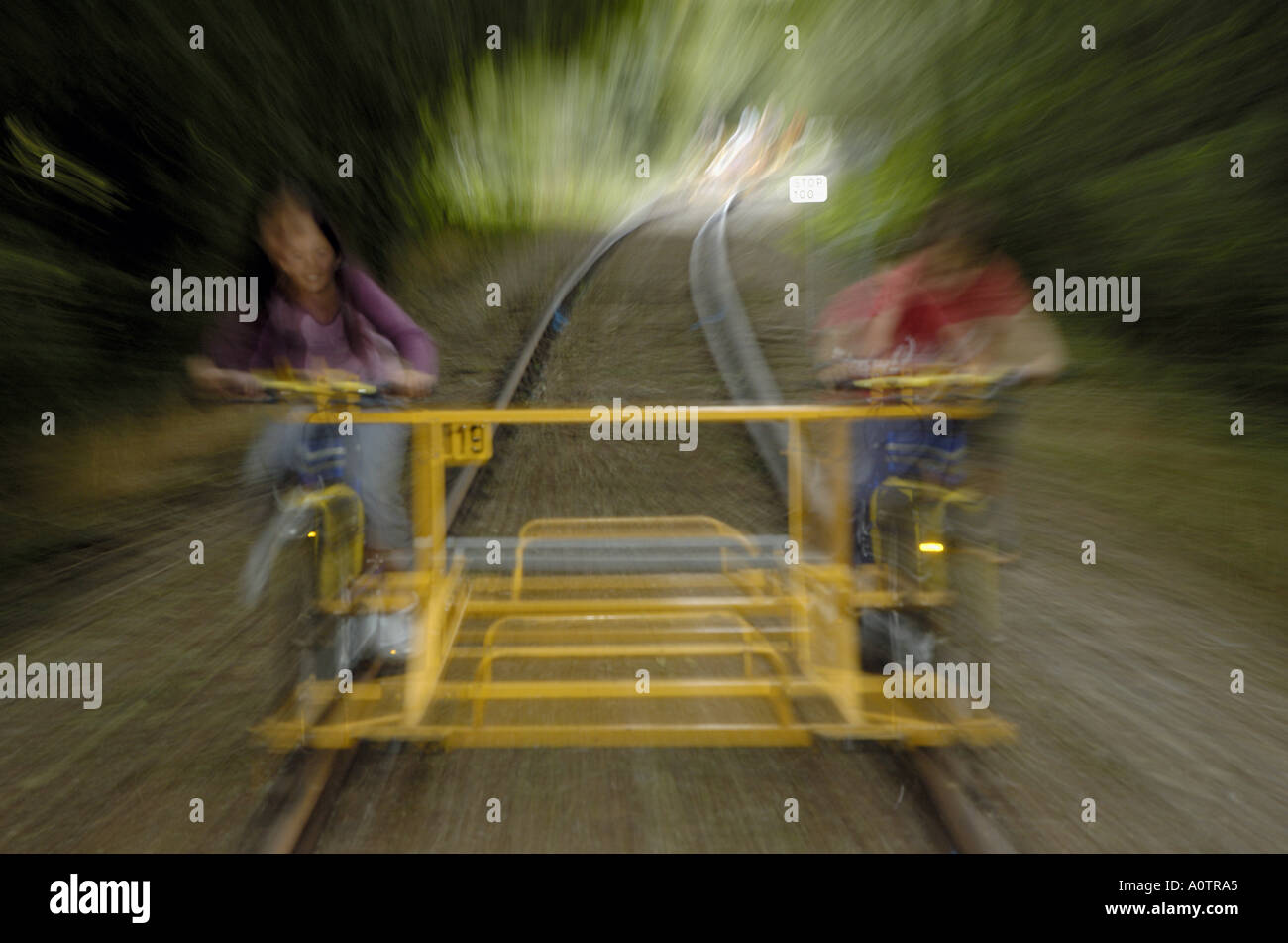 Zwei Kinder, die mit dem speziellen Fahrrad auf einem Gleis Stockfoto