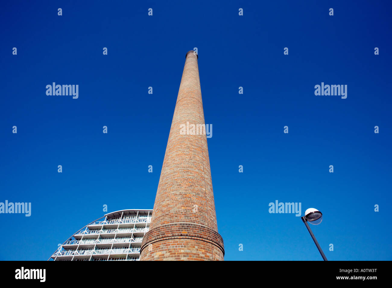 Einsamer Schornstein vor einem tiefblauen Himmel East London mit neuen Design-Wohnungen und Laternenpfahl Stockfoto