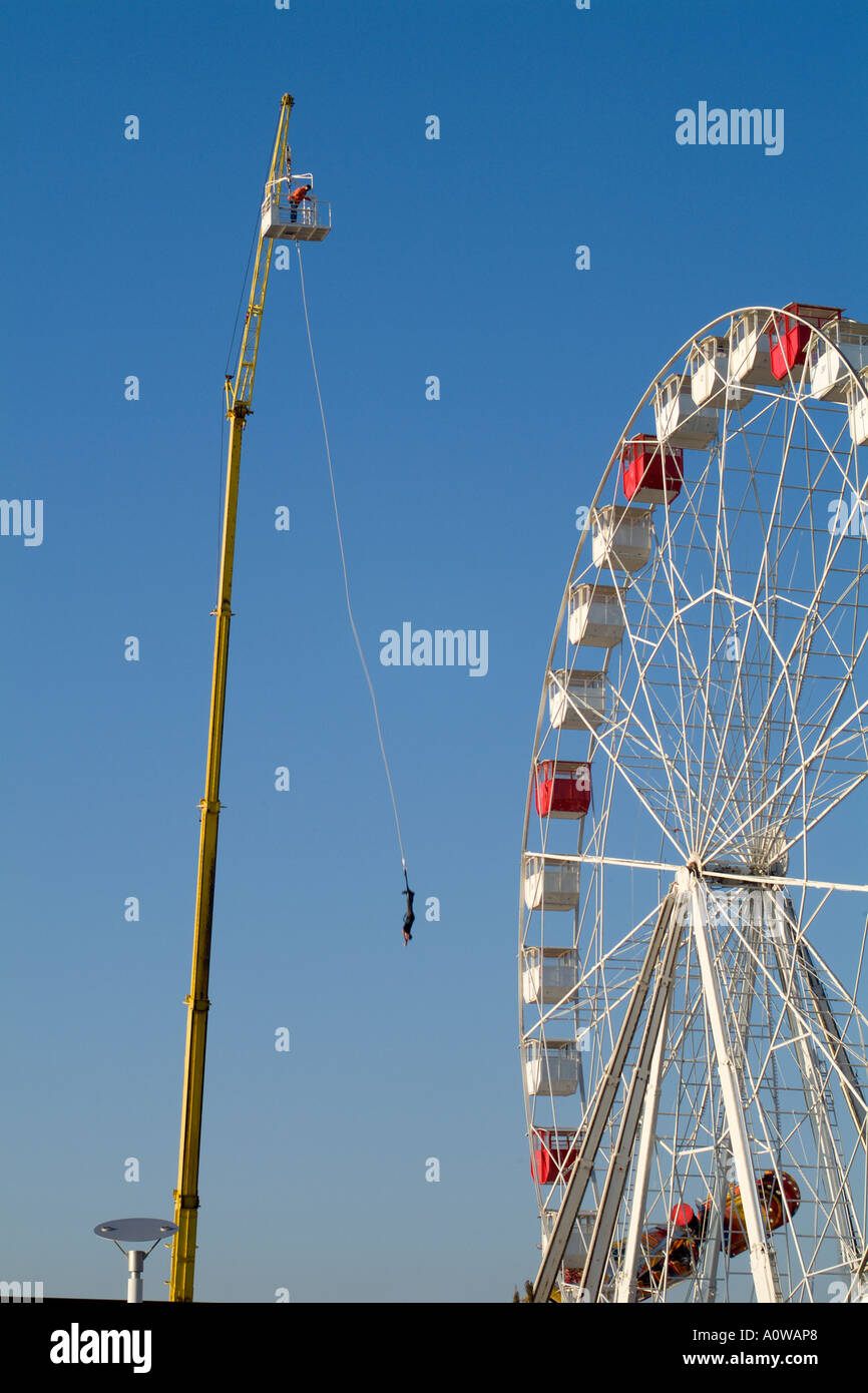 Mann auf einen Bungee-Sprung in der Nähe ein großes Rad in einem Vergnügungspark Stockfoto