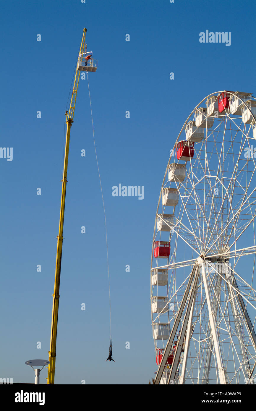 Mann auf einen Bungee-Sprung in der Nähe ein großes Rad in einem Vergnügungspark Stockfoto