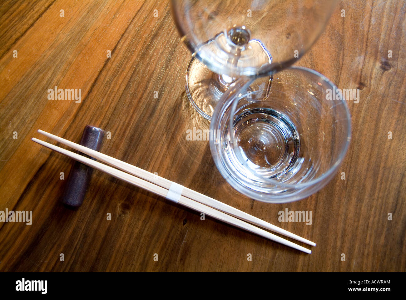 Paar Essstäbchen auf einem Tisch mit Weingläsern Stockfoto