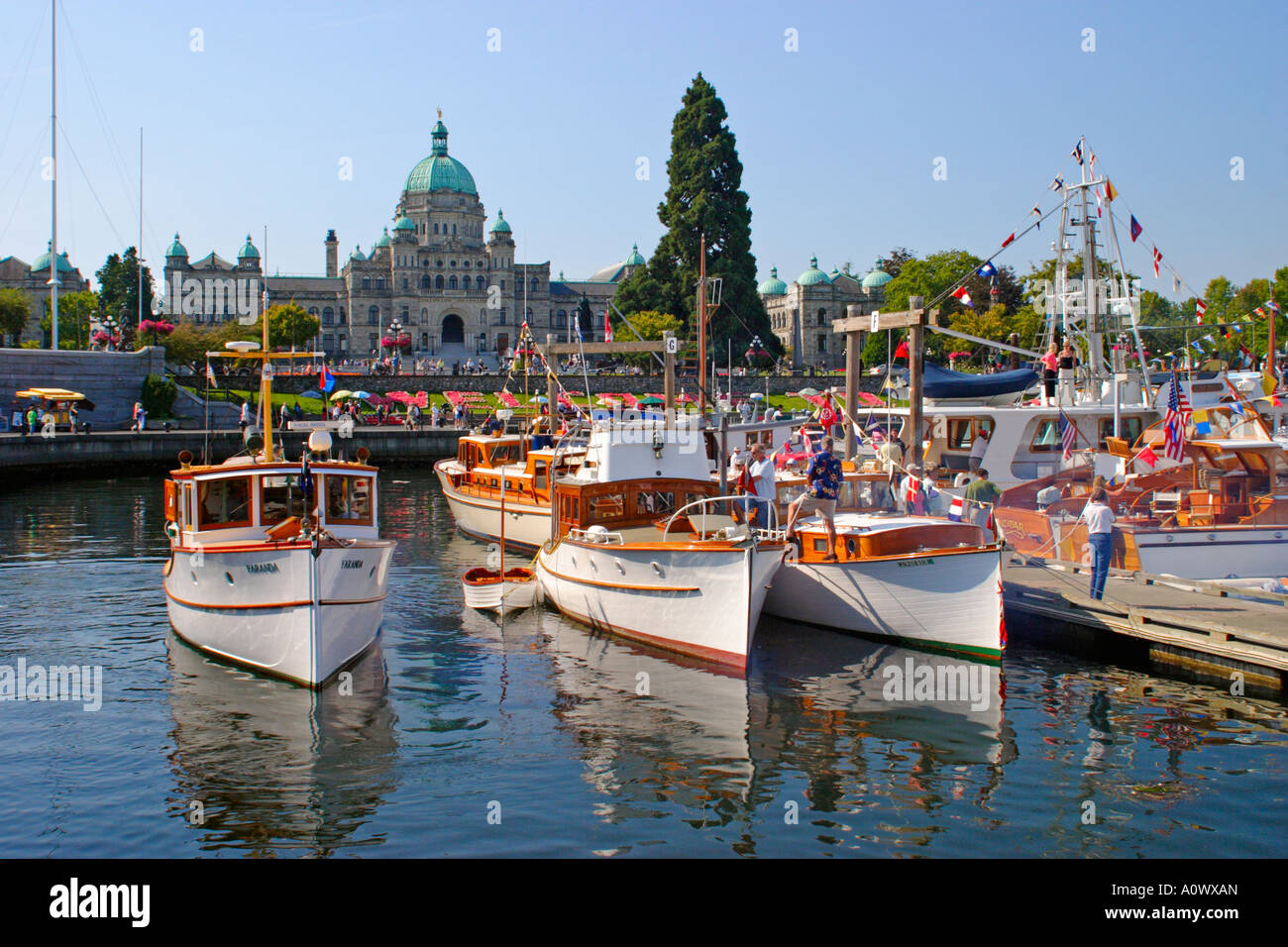 Holzboote im Victoria Harbour während der jährlichen Classic Boat Festival mit gesetzgebenden Gebäude im Hintergrund. Stockfoto