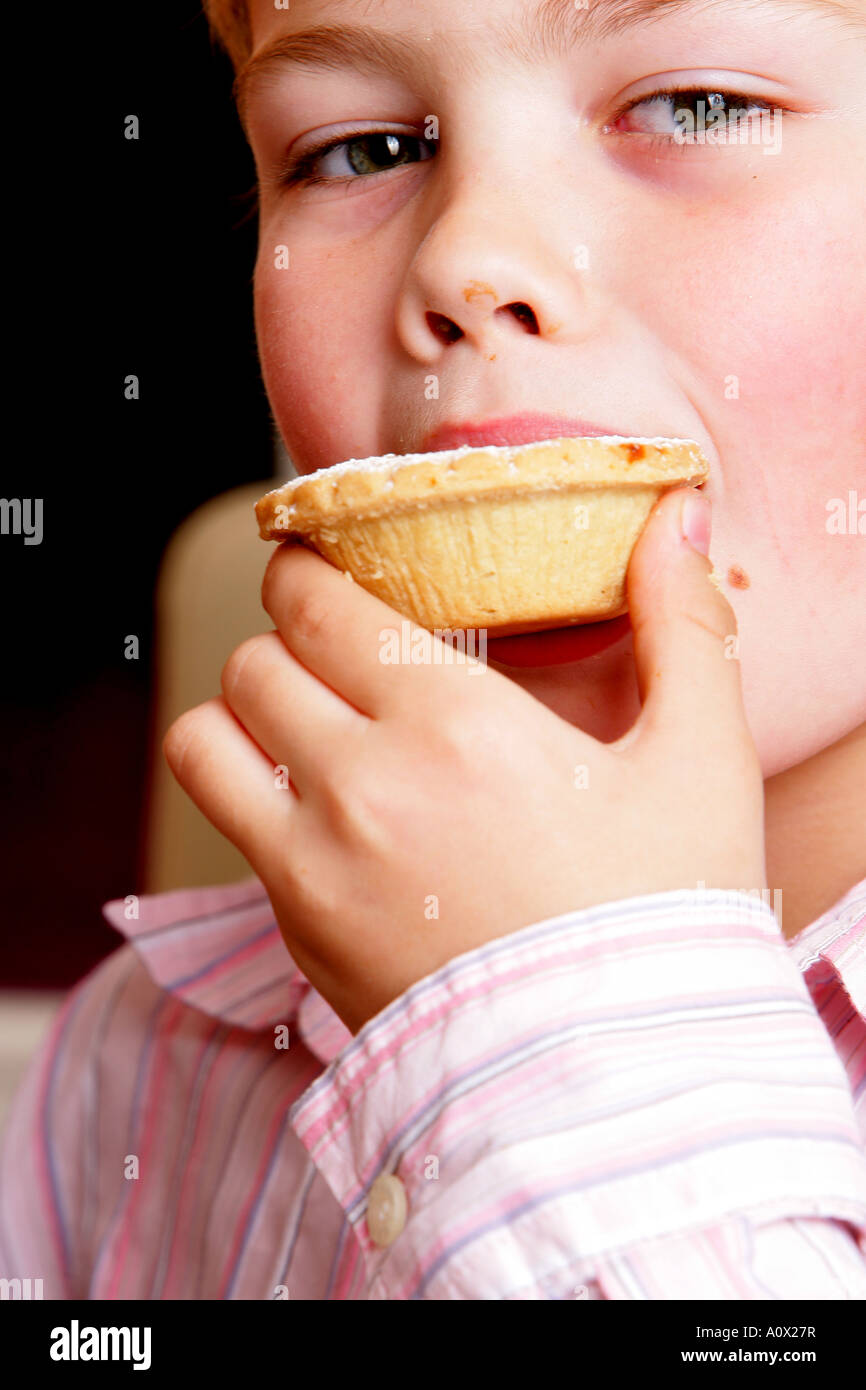 Kleiner Junge Essen ein Mince Pie-Modell veröffentlicht Stockfoto