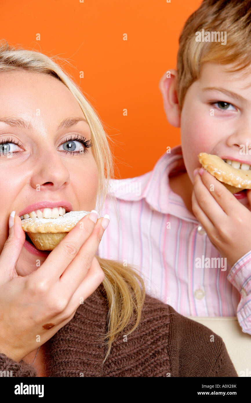 Mutter und Sohn Essen Mince Pies Modelle veröffentlicht Stockfoto