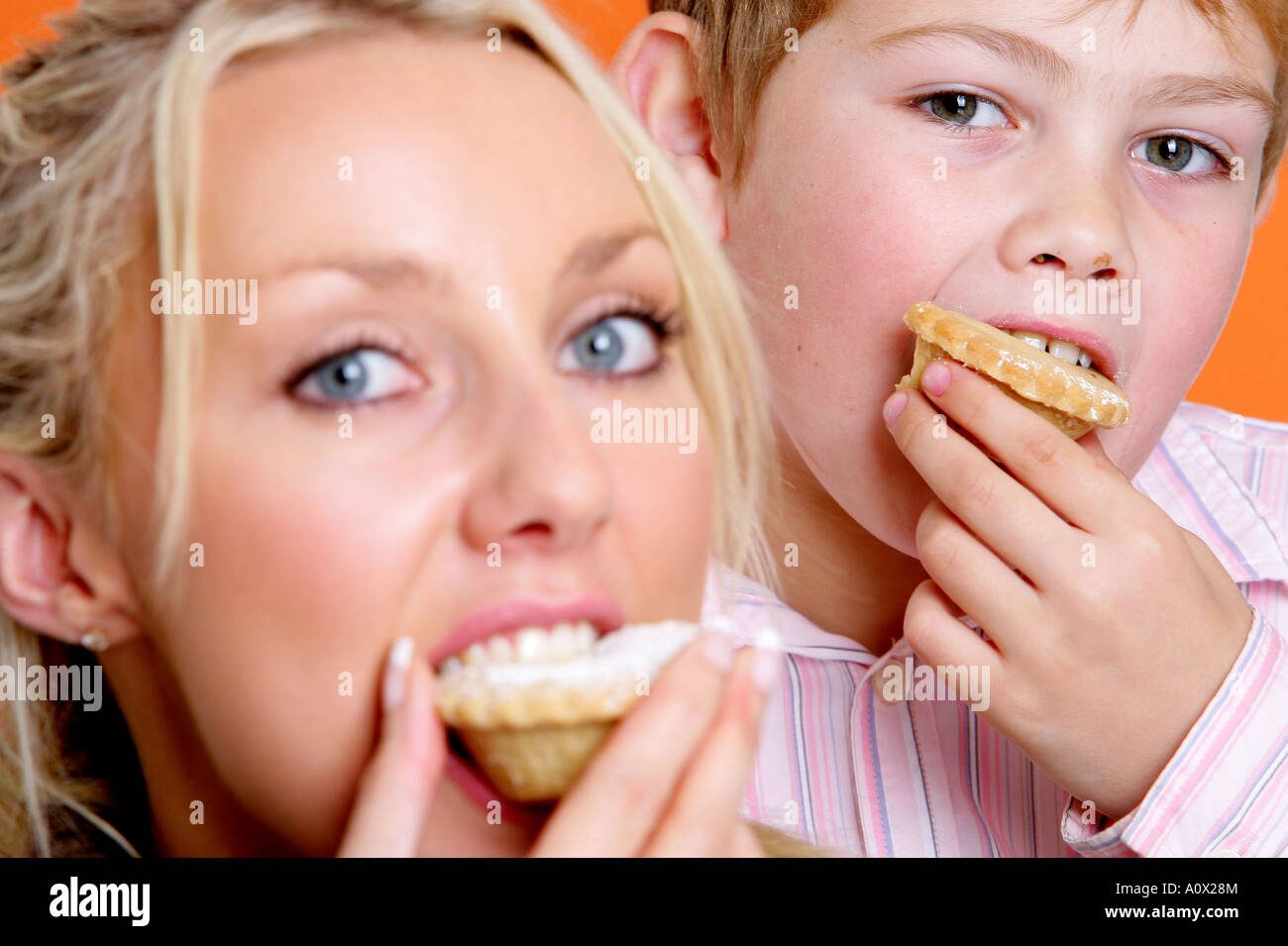 Mutter und Sohn Essen Mince Pies Modelle veröffentlicht Stockfoto