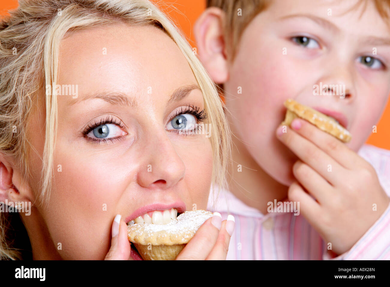 Mutter und Sohn Essen Mince Pies Modelle veröffentlicht Stockfoto