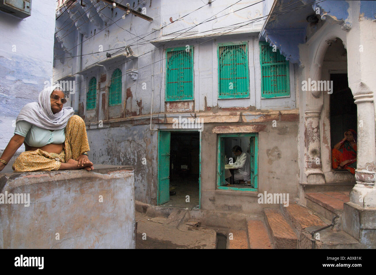 Indien Rajasthan Jodhpur die blaue Stadt alte Stadt typischen alten residencial Quartal Straßenszene mit alten Häusern ältere Frauen sittin Stockfoto