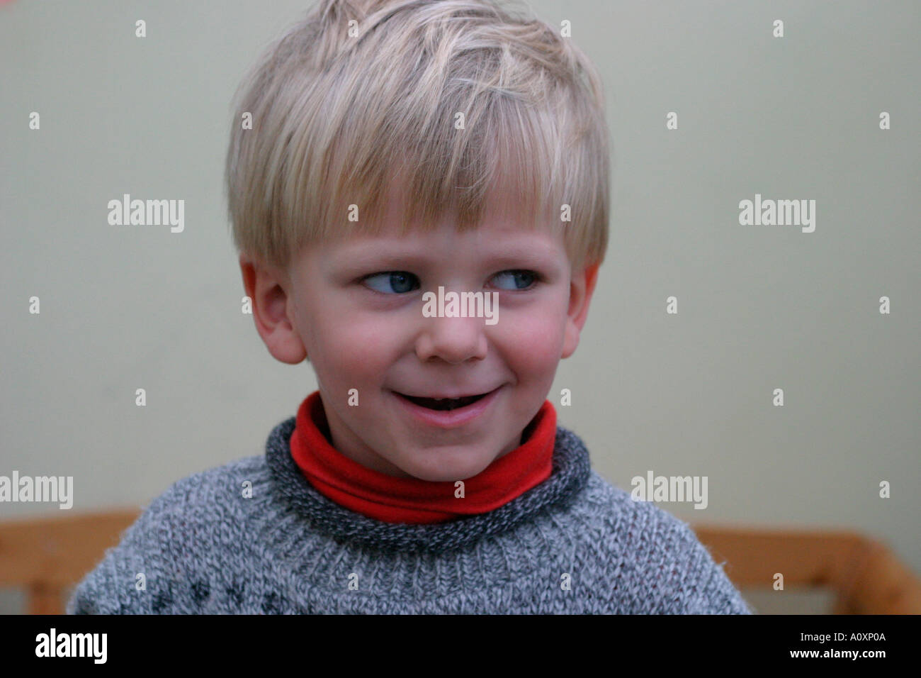 Nahaufnahme eines vier Jahre alten weißen Jungen verschmitzt lächelnd Stockfoto