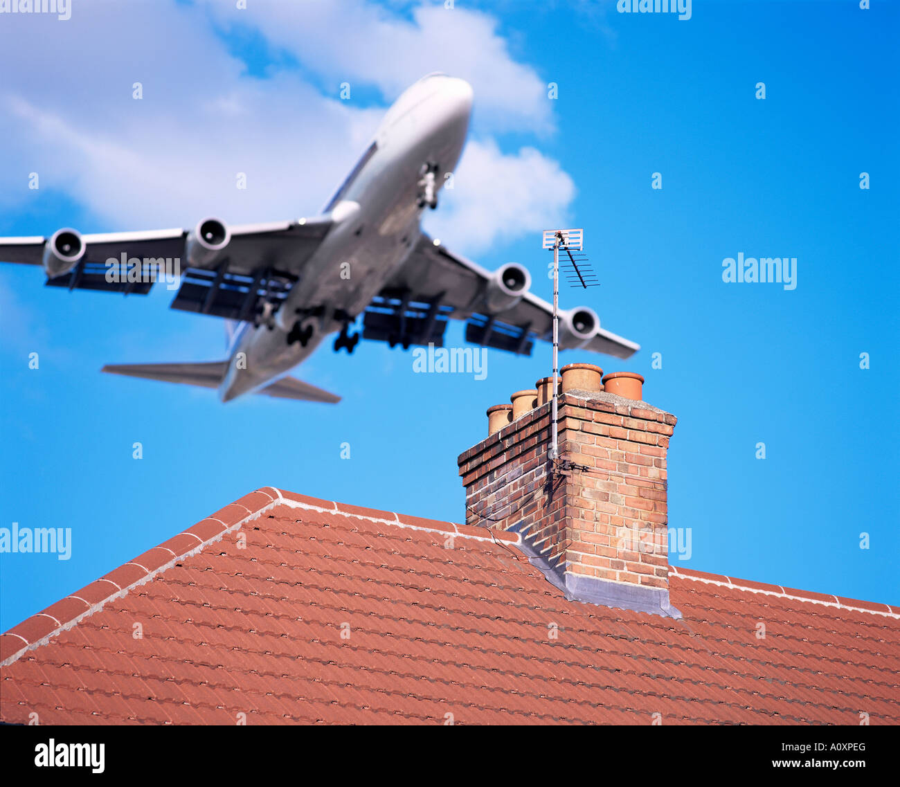 Niedrig fliegende Flugzeuge über Dächer in der Nähe von London Heathrow Airport London England Großbritannien Großeuropa Stockfoto
