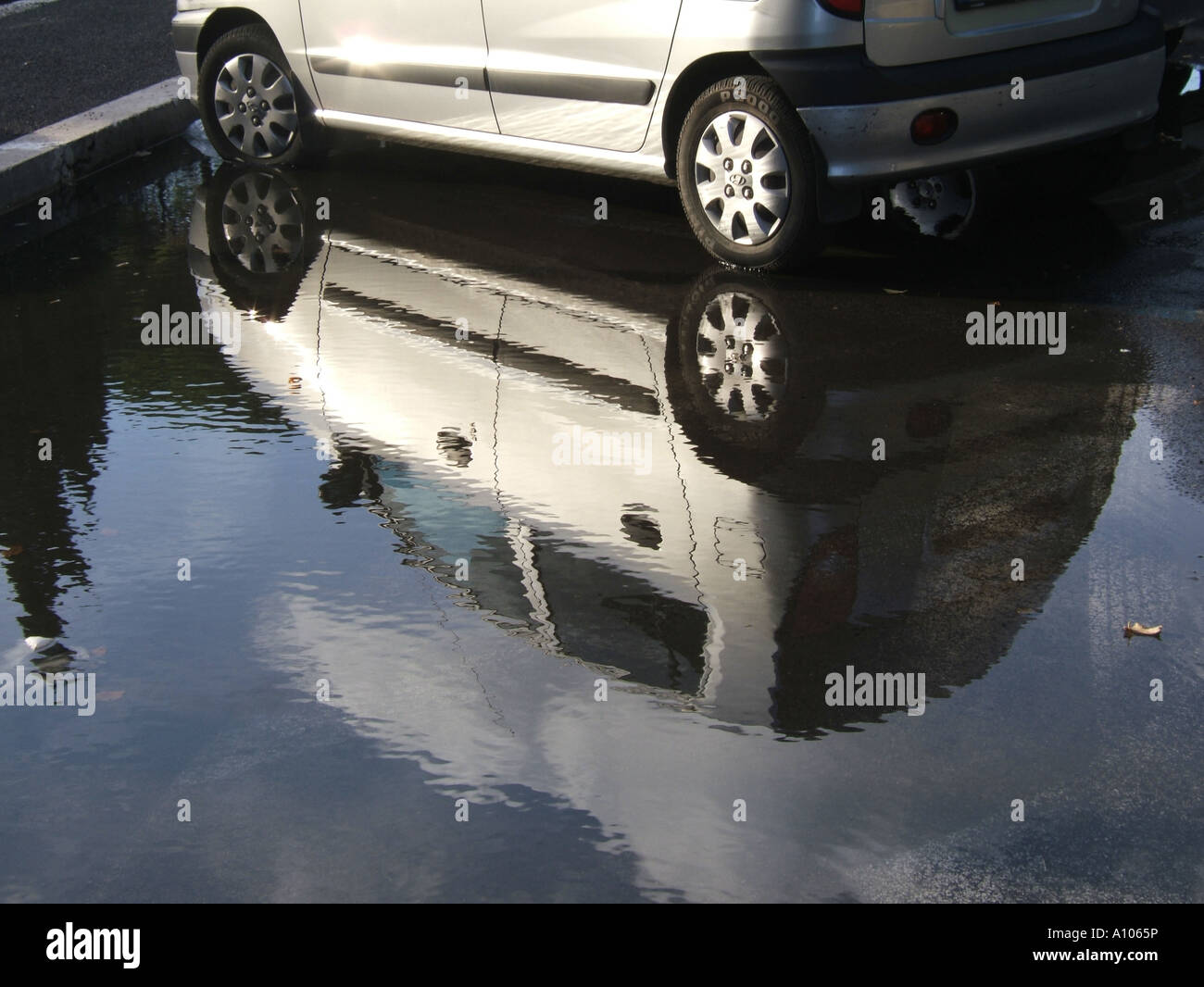 Silber geparkten Auto Reflexion über überfluteten Straße Stockfoto