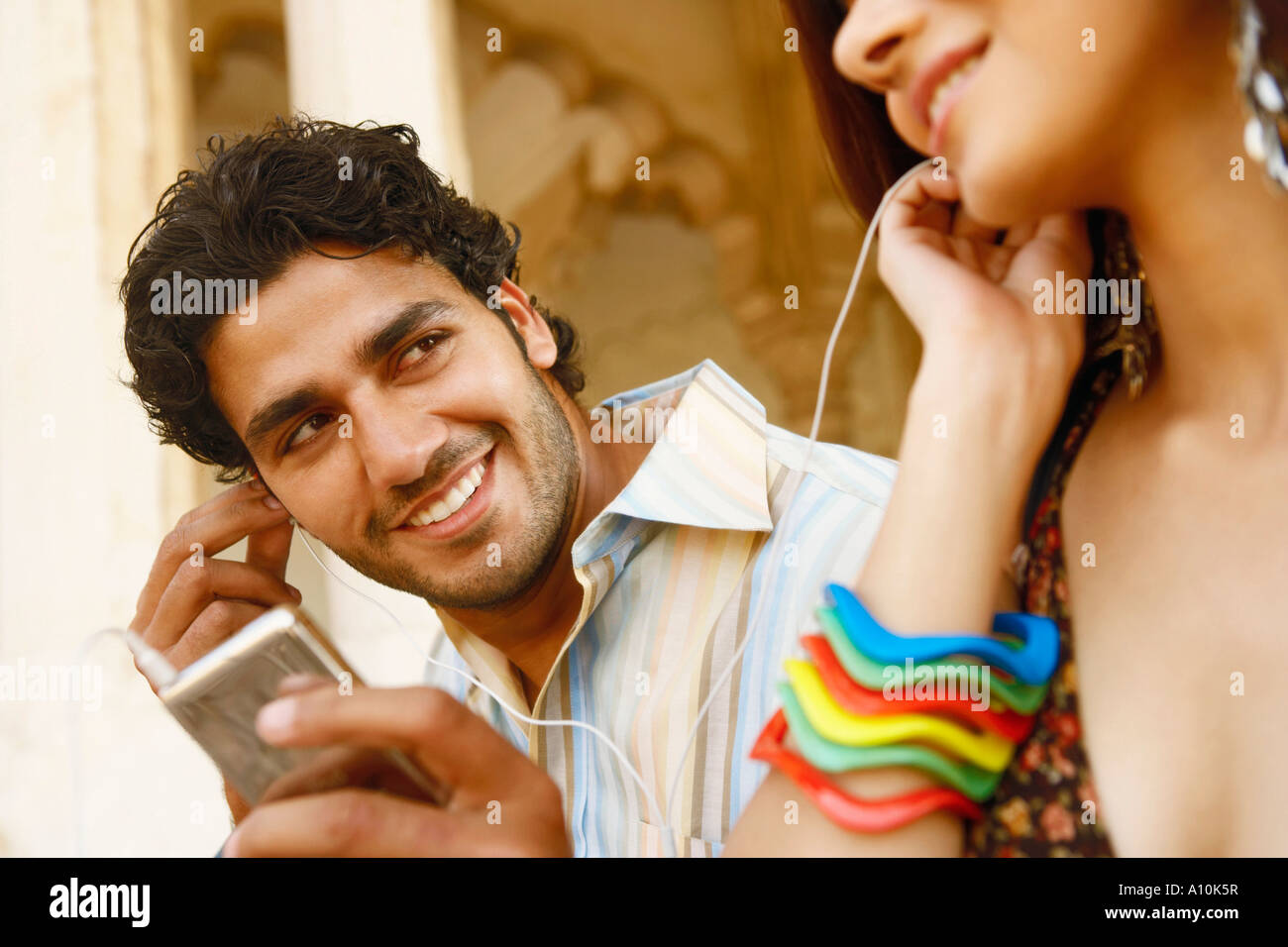 Nahaufnahme eines jungen Paares, das Anhören von Musik über Kopfhörer, Agra Fort, Agra, Uttar Pradesh, Indien Stockfoto