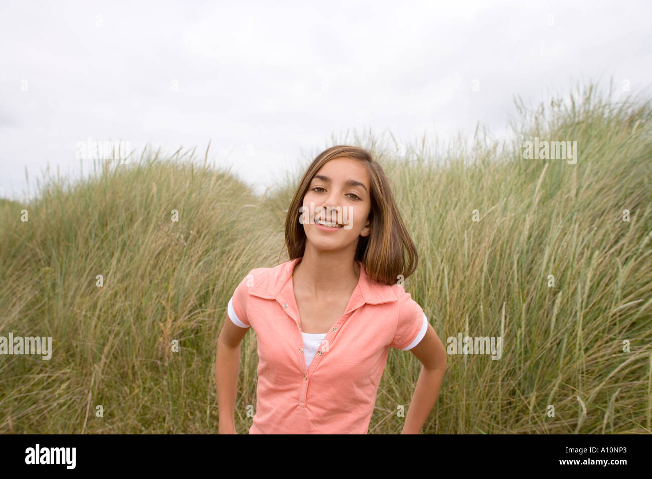 Portrait of Smiling Teenage Mädchen stehen auf Küstendünen Norfolk UK Stockfoto