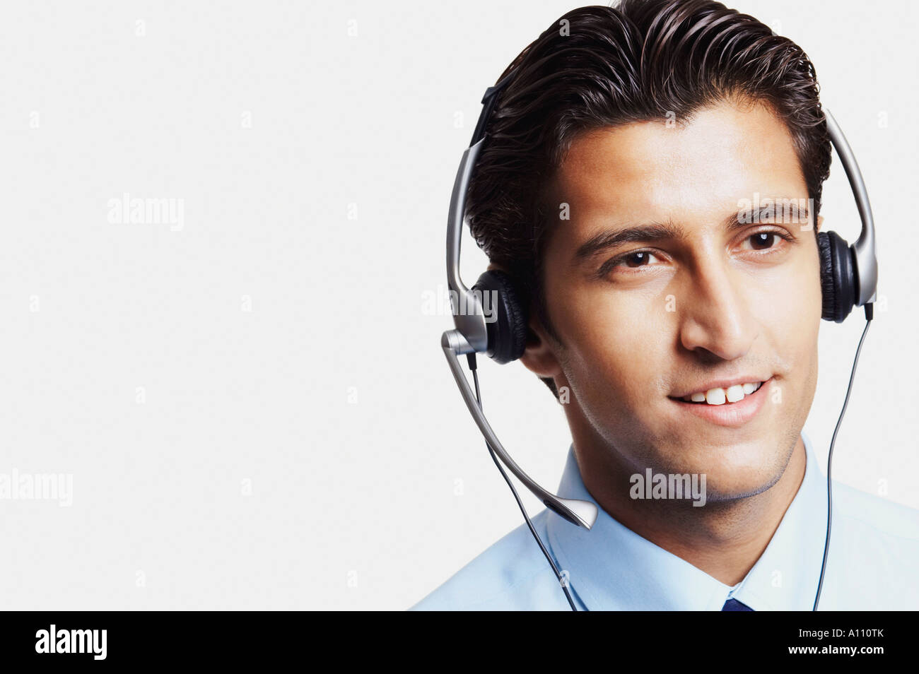 Nahaufnahme eines jungen Mannes einen Kopfhörer tragen und lächelnd Stockfoto