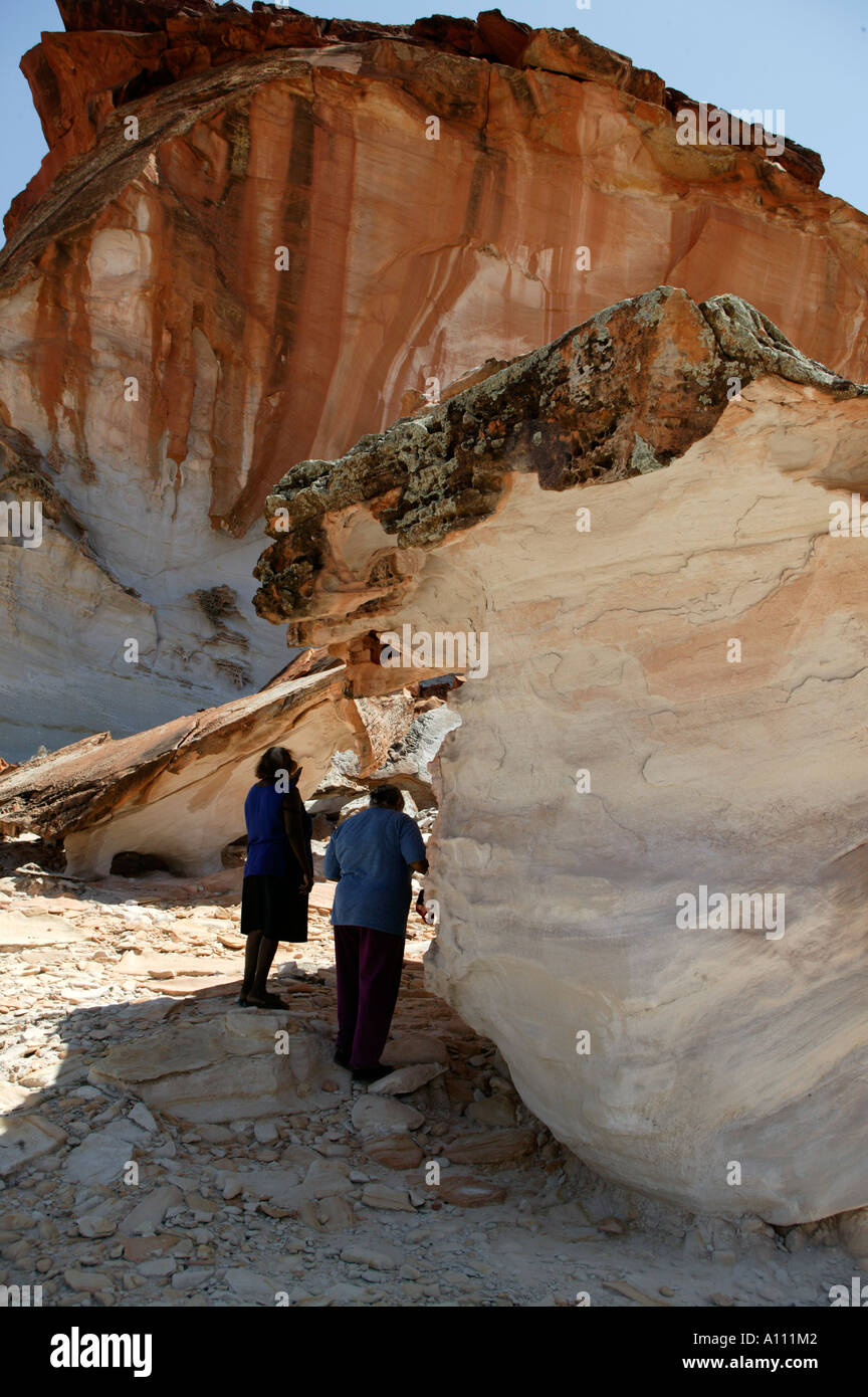 Zwei Frauen suchen Schatten, Rainbow Valley, in der Nähe von Alice Springs, Northern Territory, Australien Stockfoto