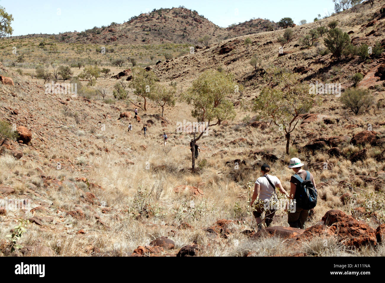 Urlauber Wandern Sie durch die Hügel als Teil eines Aborigines Urlaub, Red Centre Anangu Pitjantjara Heimat, South Australia Stockfoto