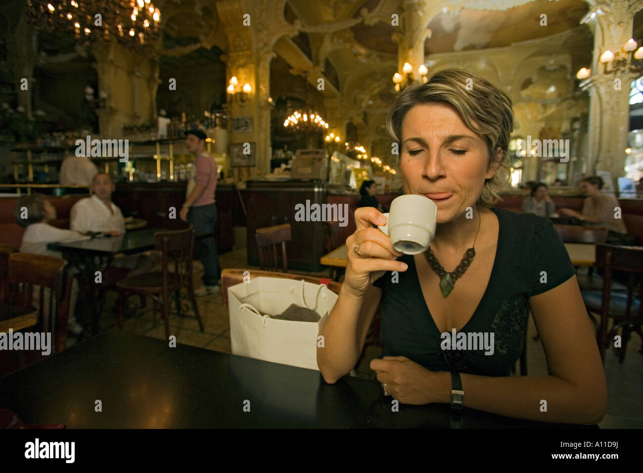 Eine junge single Frau erfreuen in einen Espresso (Moulins - Frankreich). Jeune Femme Se Délectant d ' un Expresso (Moulins - Frankreich). Stockfoto