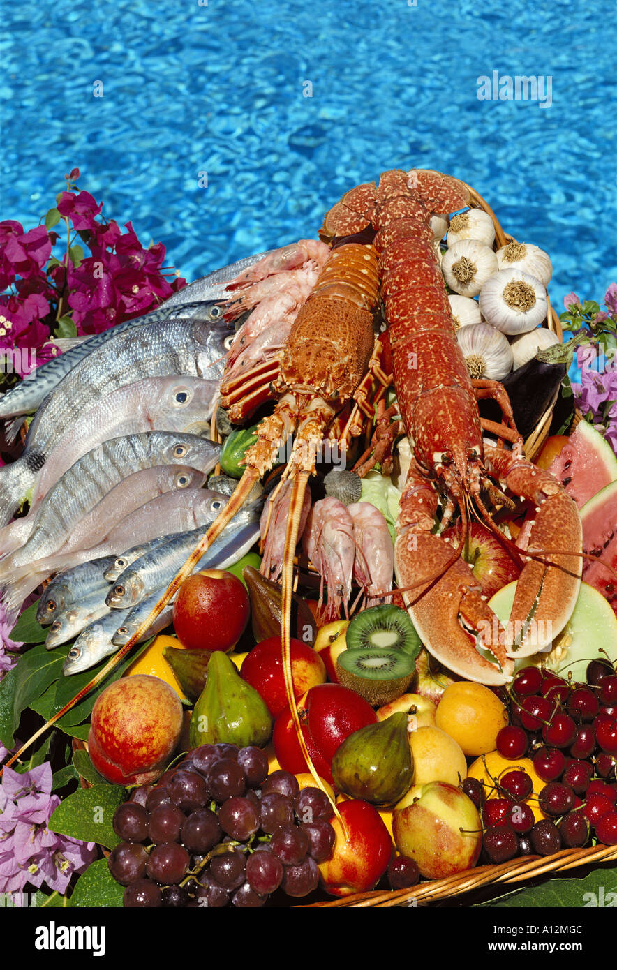 Auswahl an frischem Fisch, Hummer und Langusten mit Obst durch Swimming-pool Stockfoto