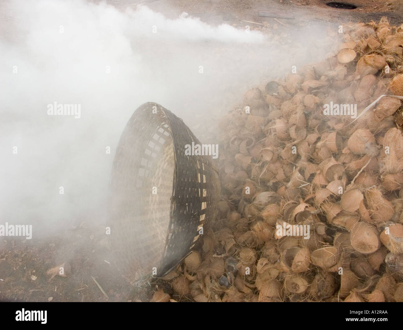 Arbeiter verbrennen Kokosnuss-Schalen im ländlichen Raum Stockfoto