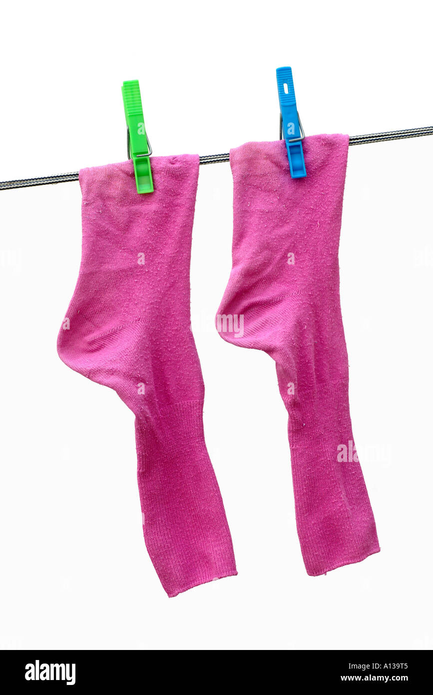 Wäsche - Socken Rosa mit grünen und blauen Wäscheklammern an einer Wäscheleine. Stockfoto