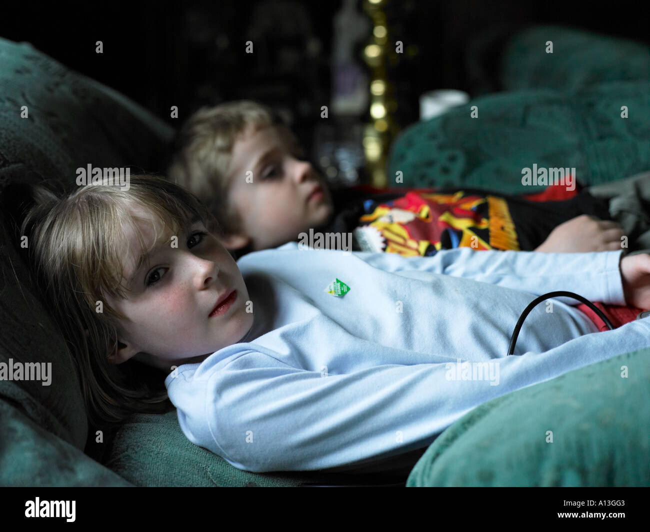 2 Kinder auf dem Sofa erholend Verlegung Stockfoto