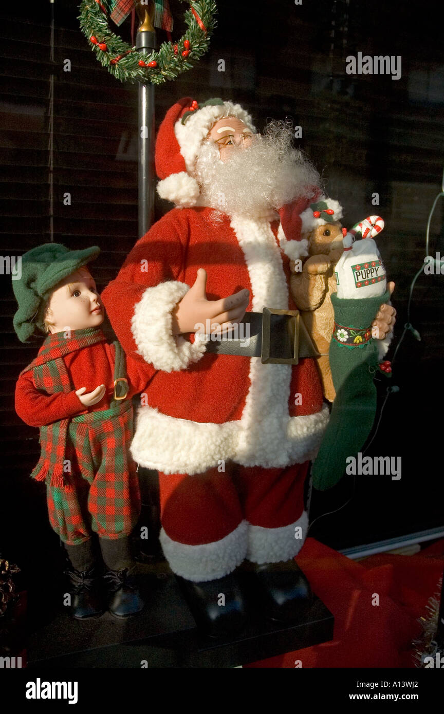 Weihnachtsmann mit Kind gekleidet rot und Tartan halten einen Welpen Stockfoto