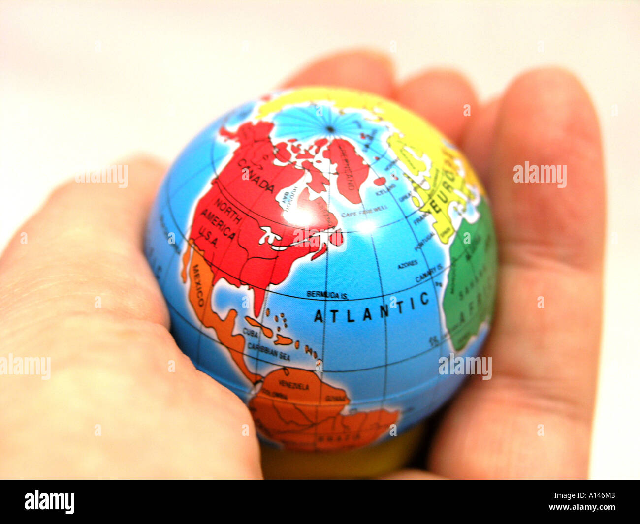 Hand hält einen kleinen Globus Stockfoto