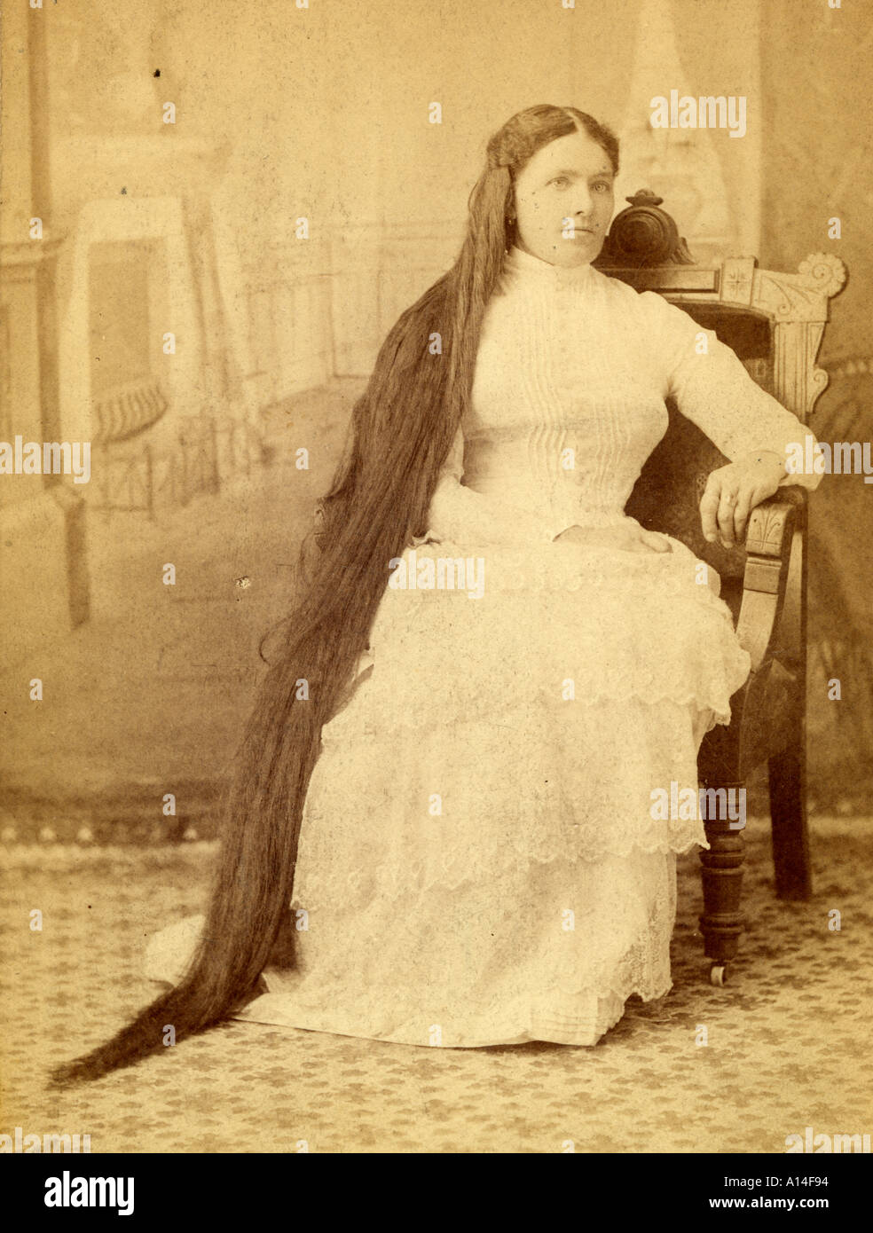 Sitzende langhaarige Frau Stockfoto