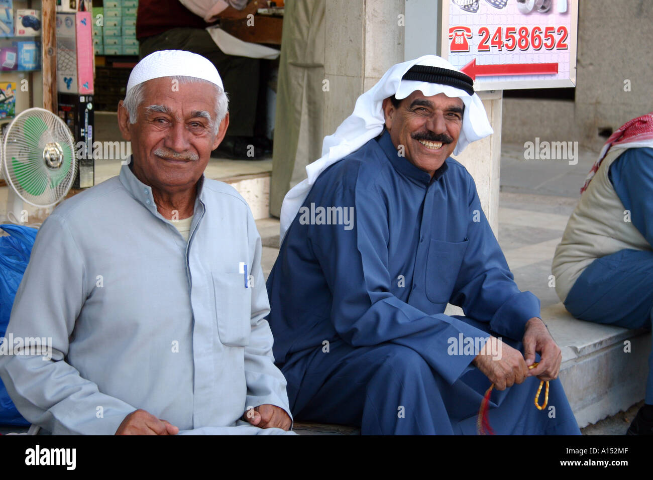 Lächelnd nahöstliche Herren gekleidet in traditioneller Kleidung Kuwait Stockfoto