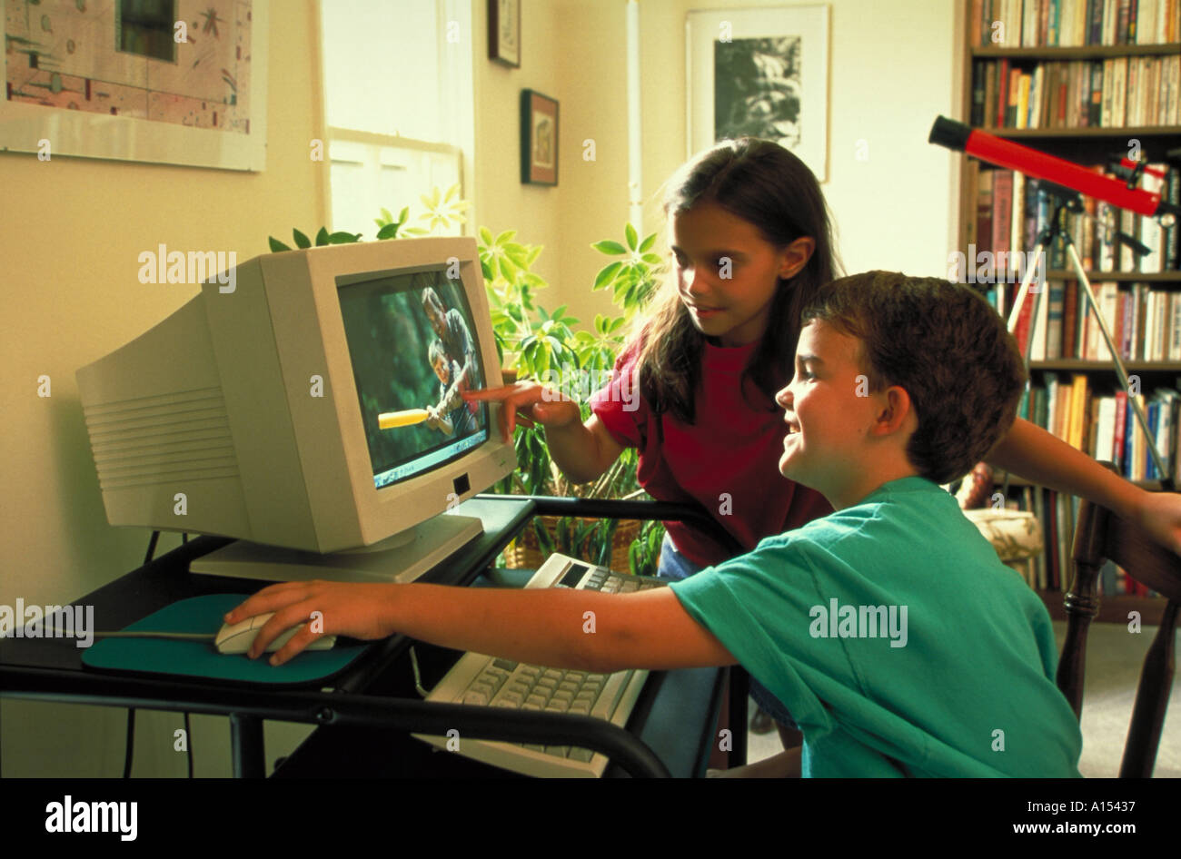 Zwei Kinder sitzen gemeinsam an einem computer Stockfoto
