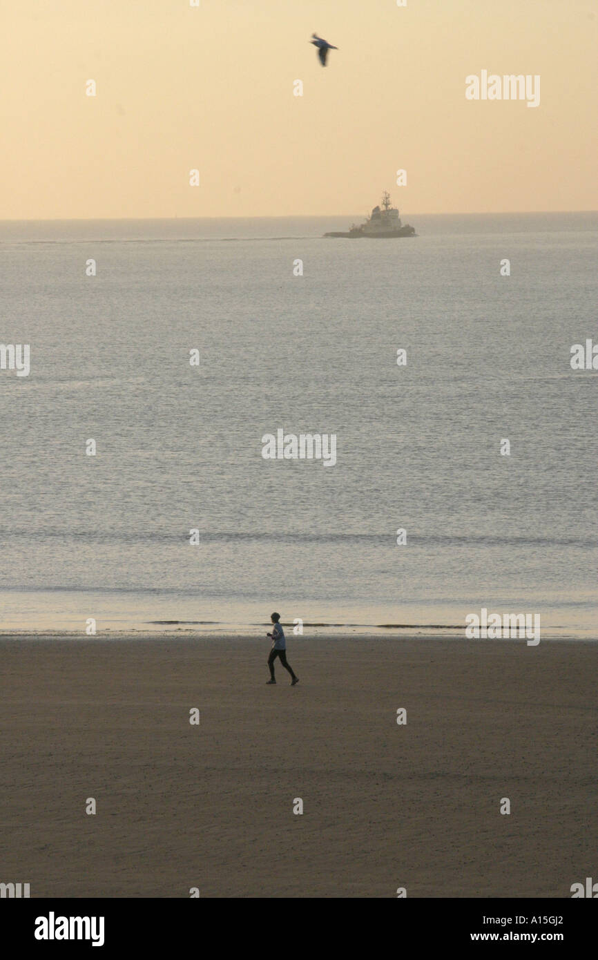 Einsamer Läufer am Strand Stockfoto