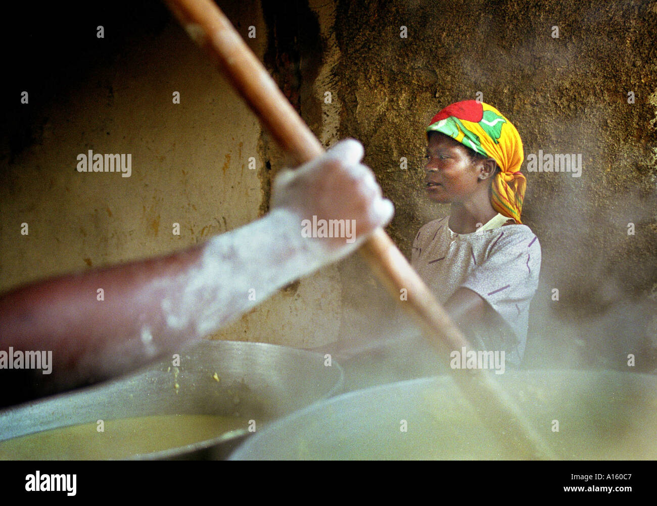 Angolanische Frauen bereiten riesige Fässern mit Sorgham, die Hunderte von intern Vertriebene in die Stadt Kuito März 2000 zu ernähren. Stockfoto