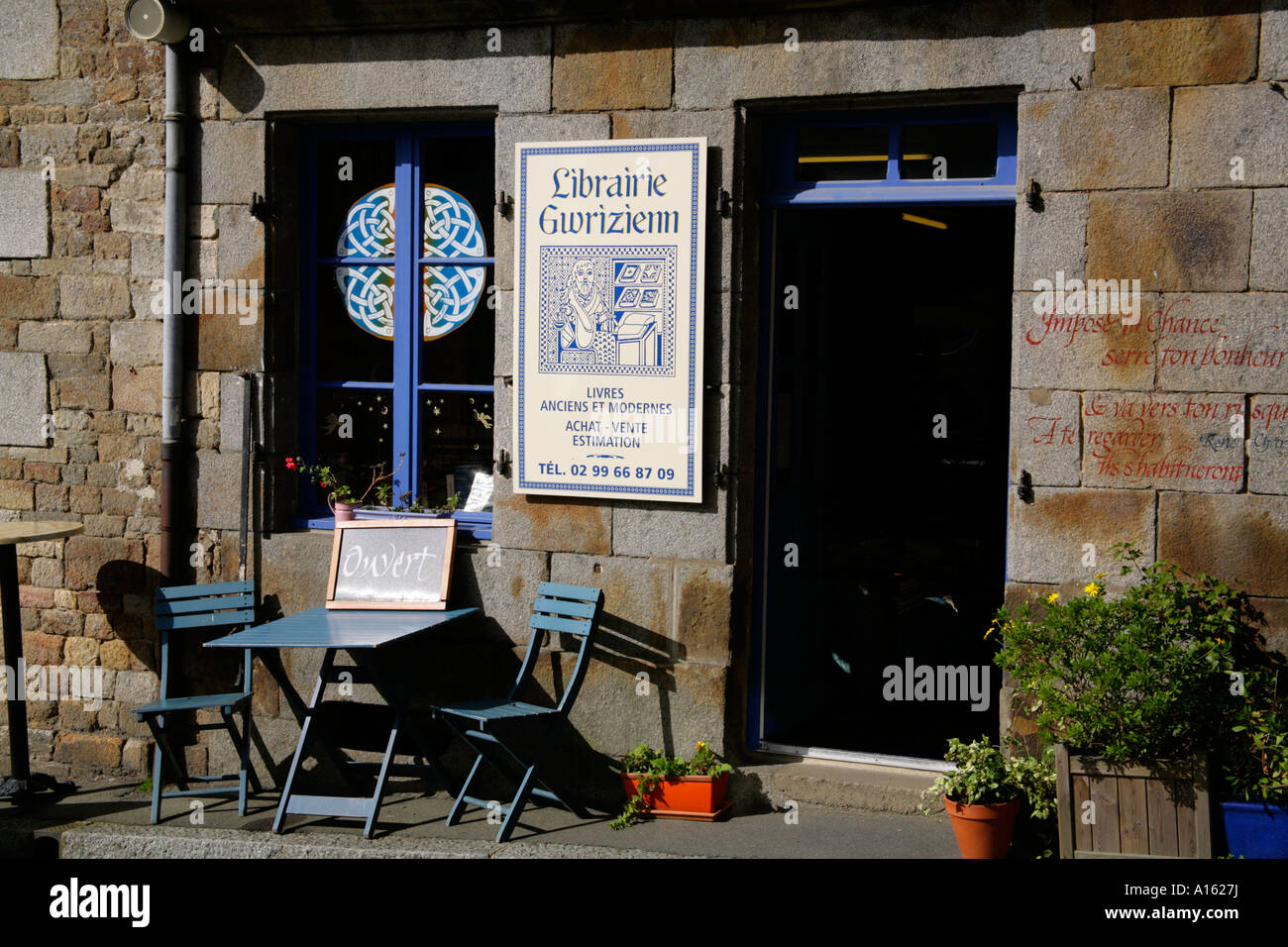 Becherel, Bretagne, Frankreich, außerhalb Librairie Gwrizienn mit Pflaster, Tisch und Stühlen. Stockfoto