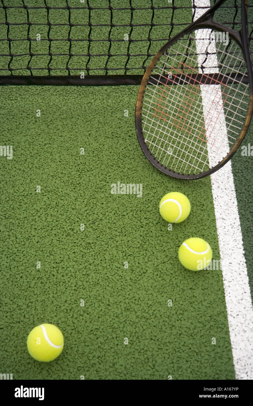 Tennisschläger und Bällen auf Tennisplatz mit Netz Stockfoto