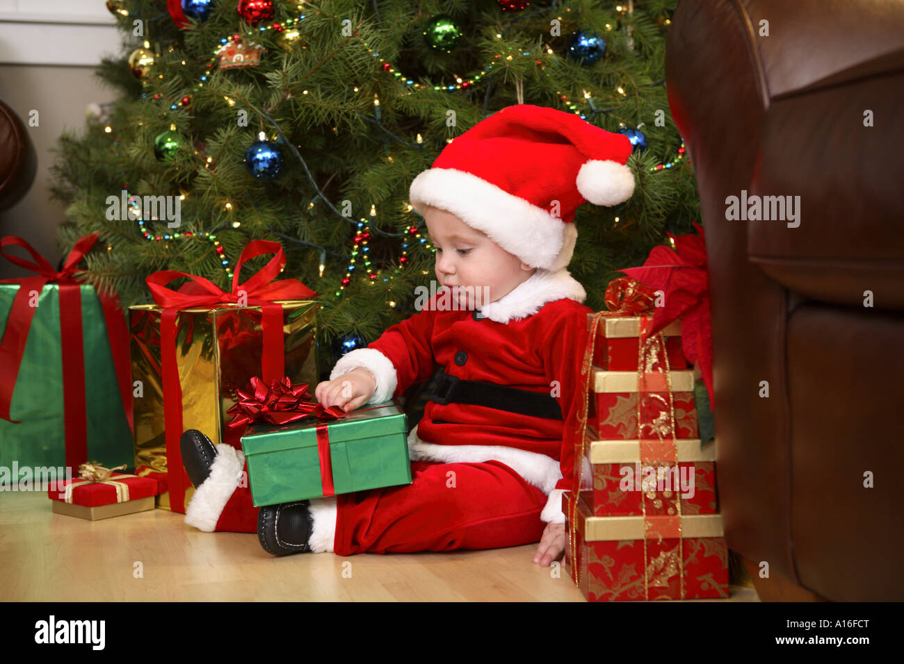 Einjähriger Junge gekleidet wie Santa Eröffnung präsentiert Stockfoto