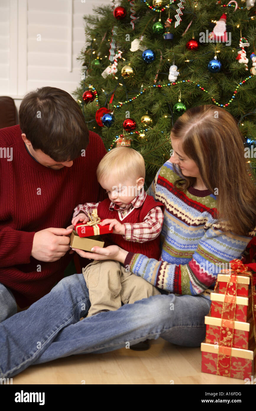 Mutter und Vater öffnen mit ihr einjähriger Sohn ein Weihnachtsgeschenk Stockfoto