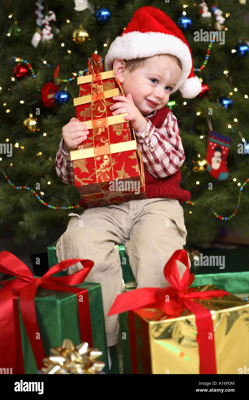 Zwei Jahre alter Junge Eröffnung präsentiert am Weihnachtsmorgen Stockfoto