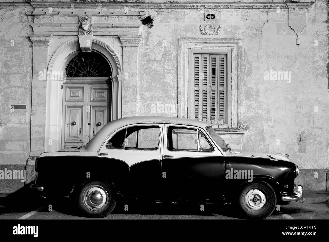 Eine alte Morris auf einer typischen maltesischen Straße geparkt. Stockfoto