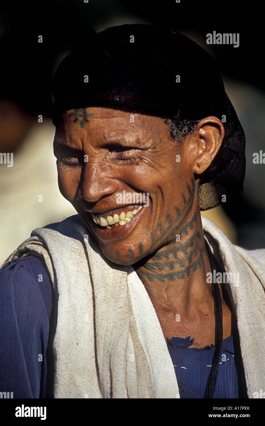 Das Amahara Lächeln, eine Amahar Frau mit vielen bunten Tattoos am Hals genießt die warme Sonnenstrahlen im Gesicht. Stockfoto