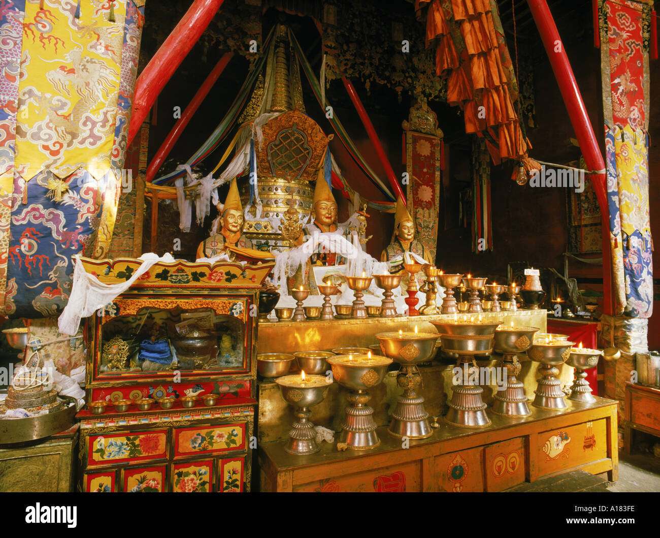 Buddhas und Butterlampen in Ganden Kloster in der Nähe von Lhasa Tibet Asien N Blythe Stockfoto