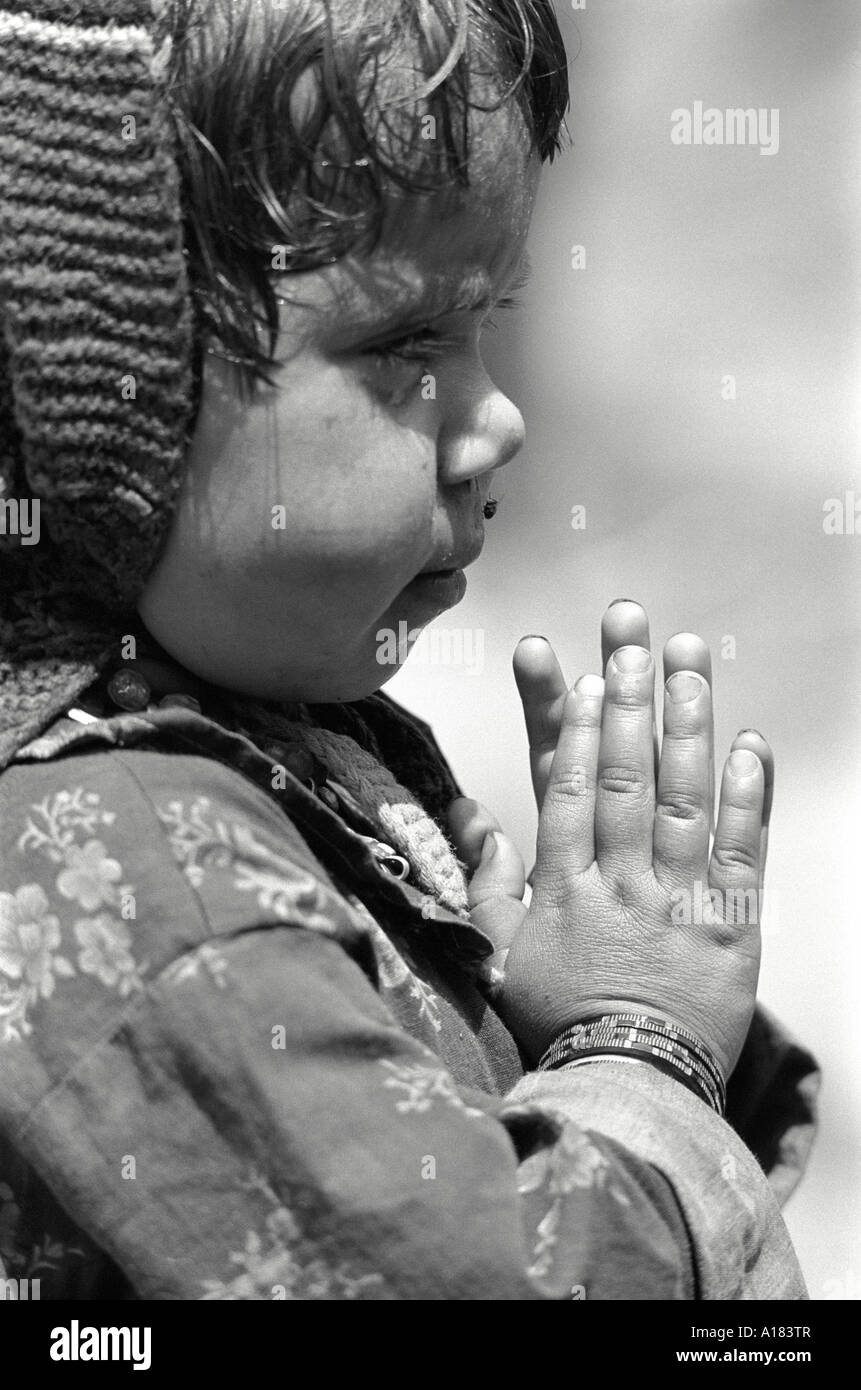 Nahaufnahme des Porträts eines jungen Kindes, das ihre gebeten auf einer Landschulversammlung sagt. Garhwal Himal, Indien Stockfoto