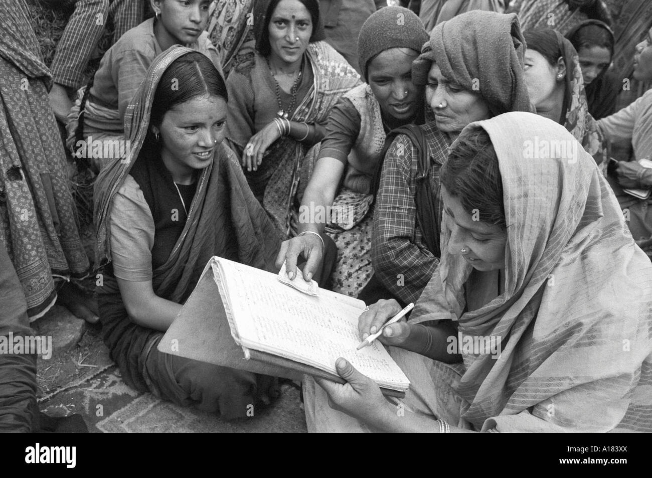 B/W einer Gruppe von Frauen in einer ländlichen Genossenschaft, an der kleine Unternehmen beteiligt sind, die ihre Konten überprüfen. Tehri Garhwal, N. Indien Stockfoto