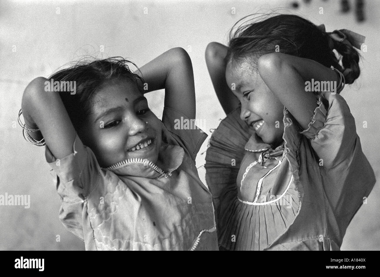 B/W von zwei lachenden jungen Mädchen, die in einem Tageszentrum tanzen und sich um die Kinder von Prostituierten kümmern.Kalkutta, Indien Stockfoto
