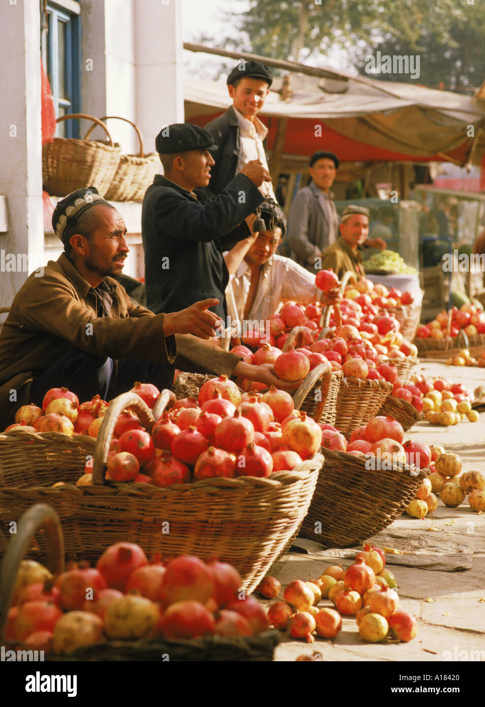 Männer verkaufen Granatäpfel in der Sonntagsmarkt in Kashgar Xinjiang Provinz China N Blythe Stockfoto