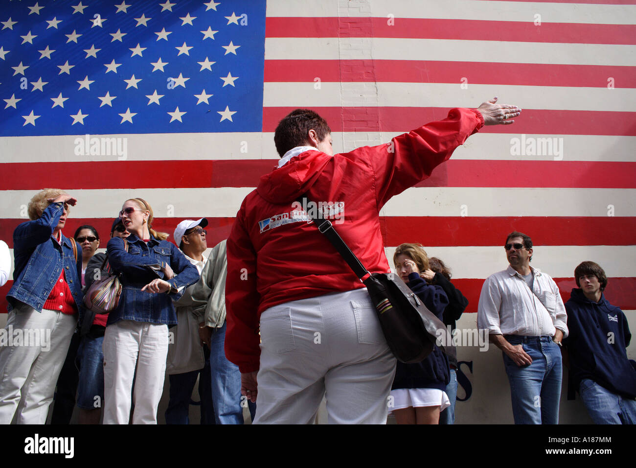 Ein Enthnically Diverse Reisegruppe vor einer großen amerikanischen Flagge, San Francisco, Kalifornien Stockfoto