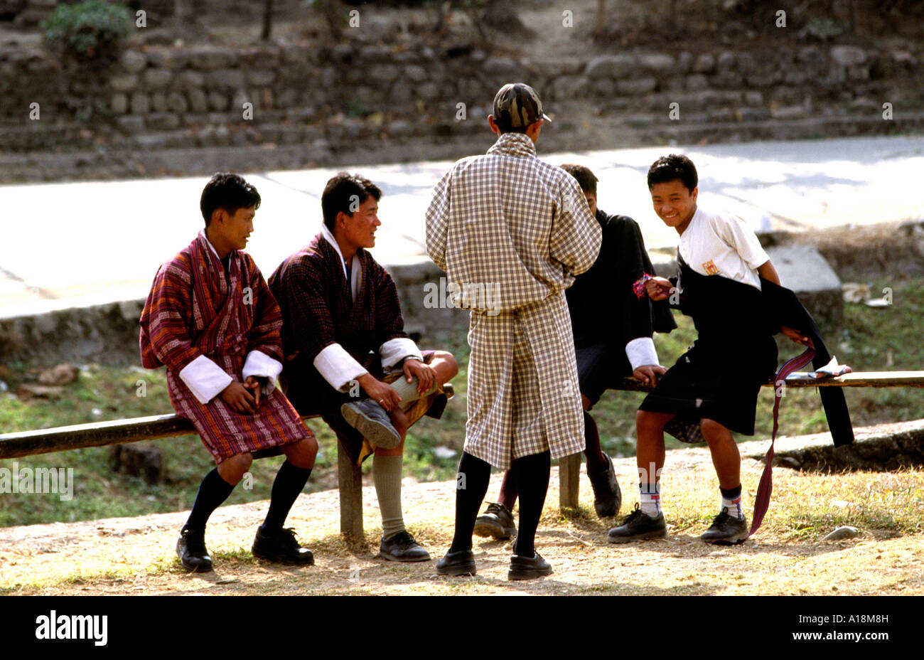 Bhutan Rinchending bhutanischen Jünglinge tragen Tracht Gho am Straßenrand sitzen Stockfoto