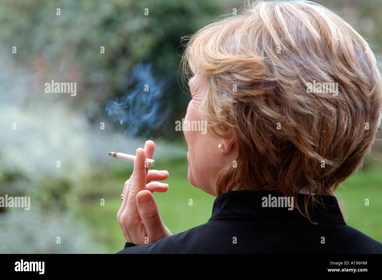 Frau raucht eine Zigarette Exhaling Tabakrauch Stockfoto
